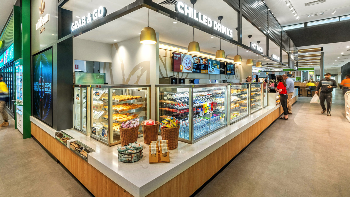 Modern convenience store interior with chilled drinks and snacks on display.