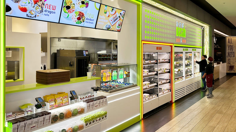 Modern convenience store interior with refrigerated shelves and digital displays.